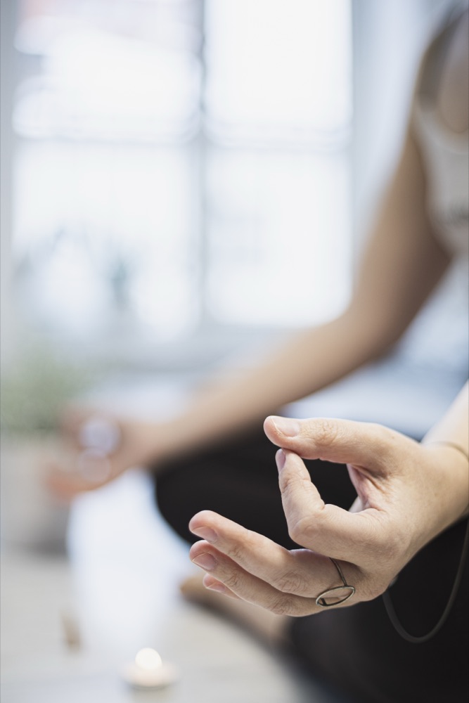 A hand resting in a soft mudra during seated meditation
